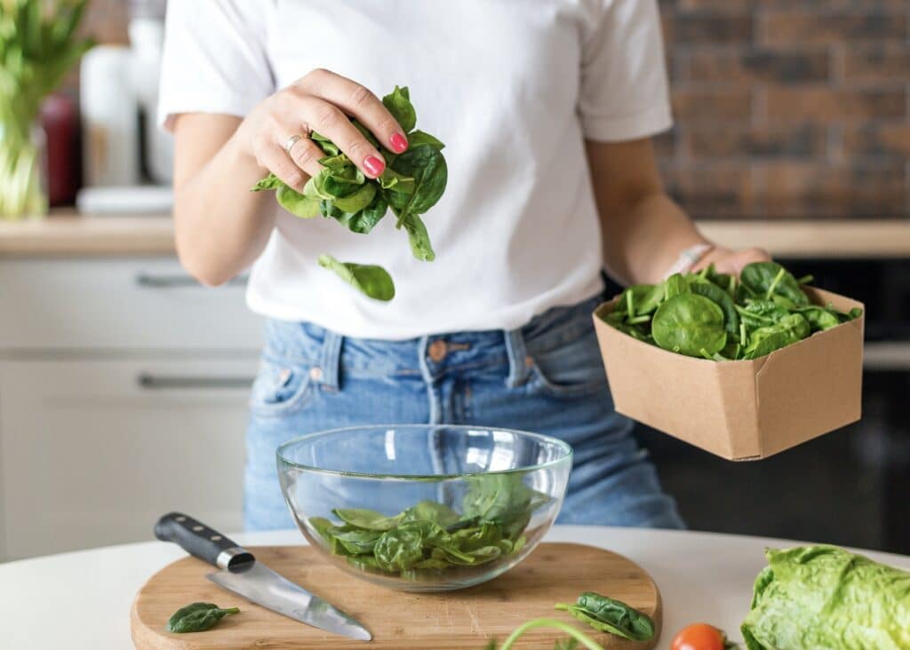 Woman preparing spinach in the kitchen